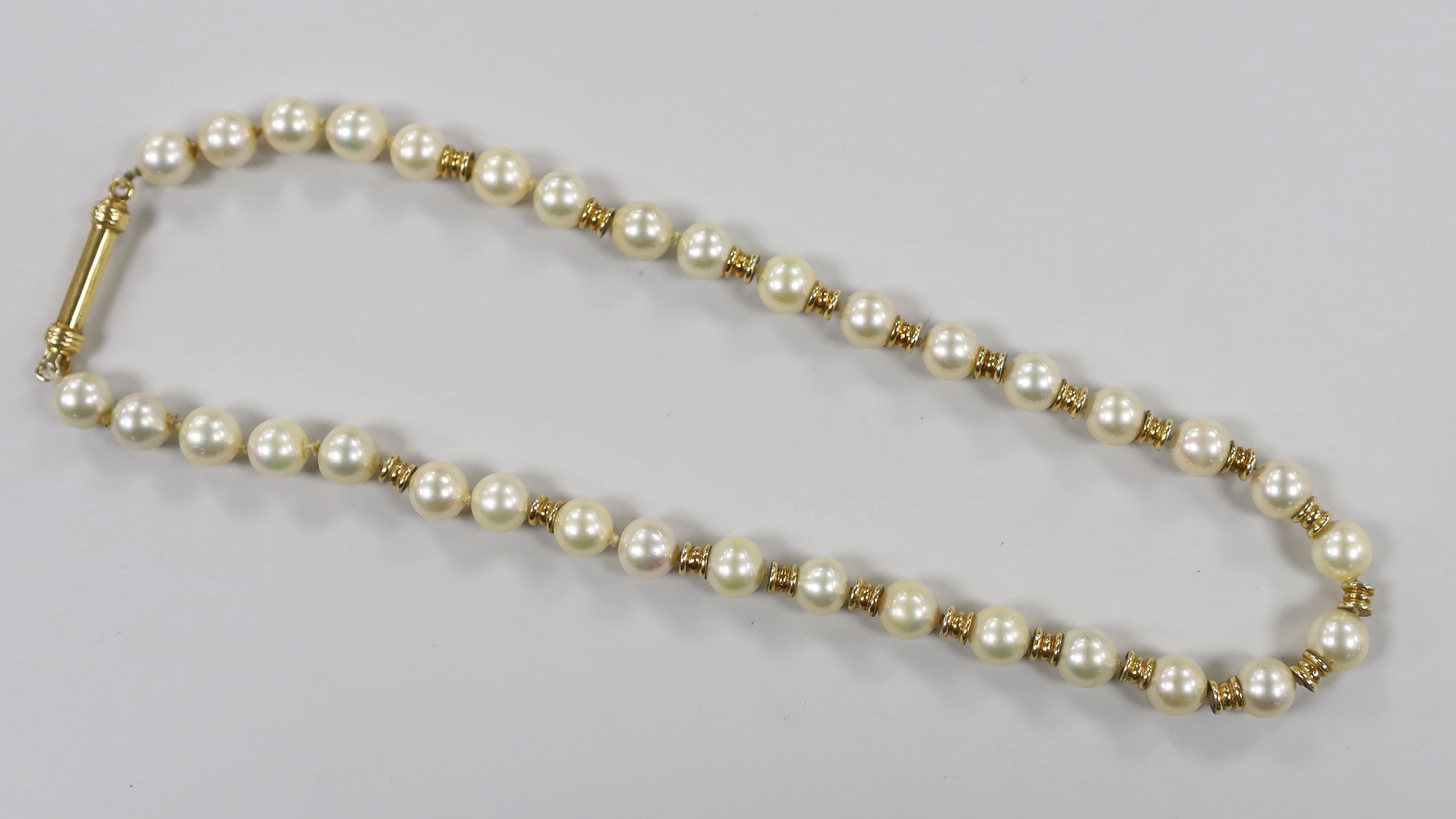 A mid 20th century Italian 750 yellow metal and cultured pearl set single strand necklace, with yellow metal spacers, 38cm, gross weight 38.9 grams.